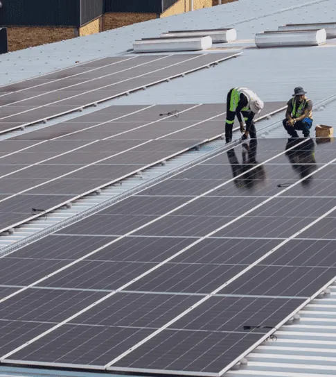 Solar installer assembling a rooftop PV mounting system with rails, clamps and roof hooks