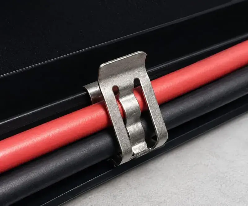 Double-wire solar panel cable clip holding two PV cables below a module frame