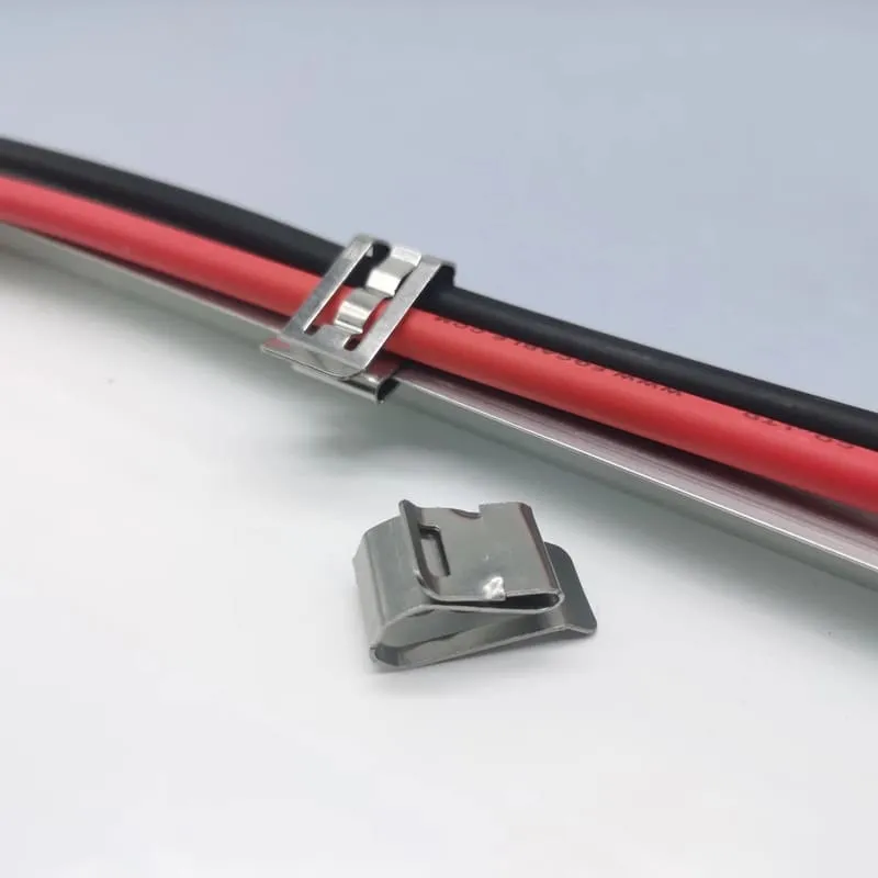 Solar cable clip holding PV wires below a framed module and away from the roof surface